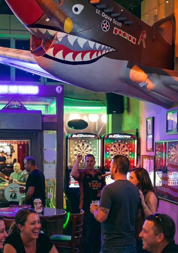 Playing electronic darts under the P-40 Warhawk at Bad Monkey