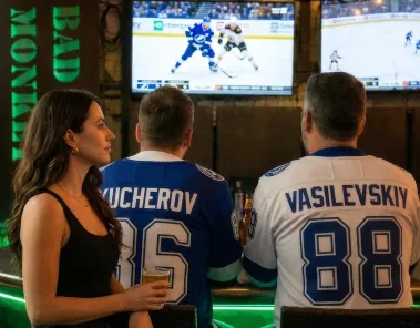 Lightning fans in jerseys watching hockey at the bar